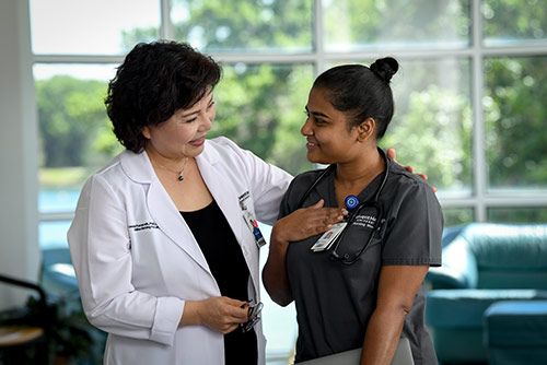 A nursing student conversing with faculty
